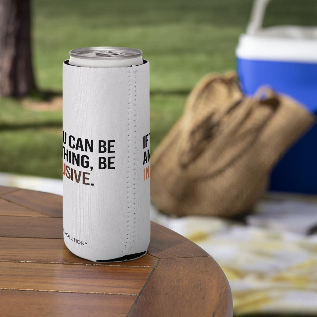 A slim 12 oz Inclusive Diversity Koozie. On the front of the neoprene diversity koozie, in upper-case letters printed on a white koozie, is the phrase, "If you can be anything, be inclusive." The text is all black except for the word "Inclusive," which is in different skin colors, with the lightest color on the left and the darkest on the right promoting racial equality. The koozie is on a picnic table.
