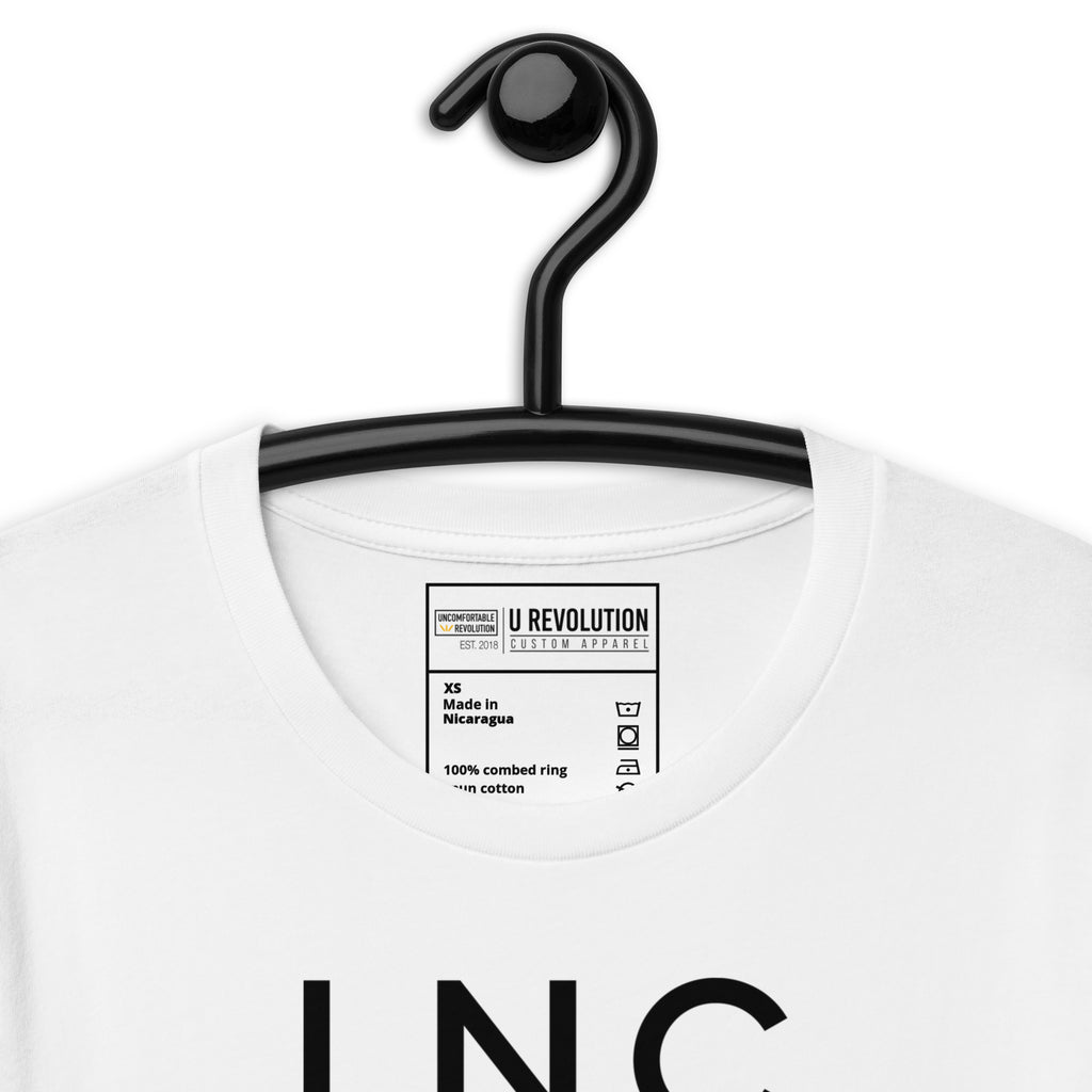 Close-up of the white INCLUSIVE Statement Tee typography – bold and minimalist lettering arranged in three-line format, representing diversity and inclusion.