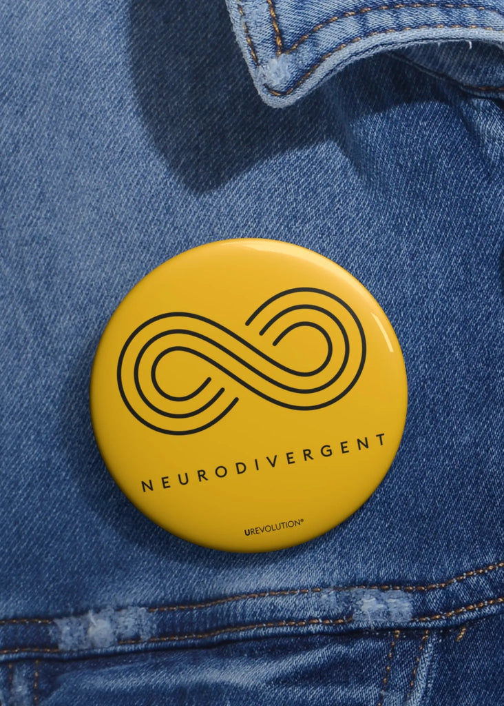 Gold Neurodivergent Pin-Back Button worn on a jacket, symbolizing autism acceptance and advocacy.