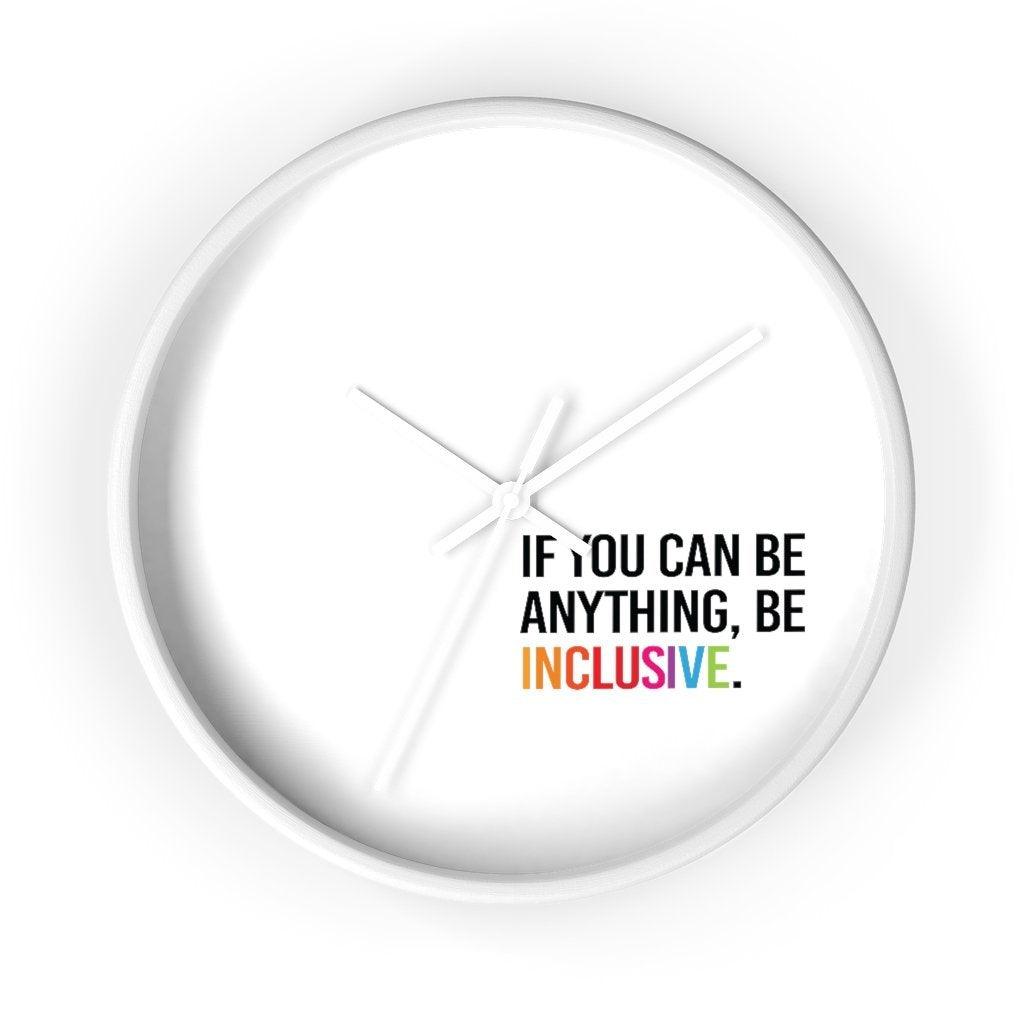 The clock has a white wooden frame and a white face. The hands are white and there are no numbers. In the bottom white quadrant of the clock face is text printed in all caps: "IF YOU CAN BE ANYTHING, BE INCLUSIVE." All text in black, except "Inclusive" which is in rainbow colors.