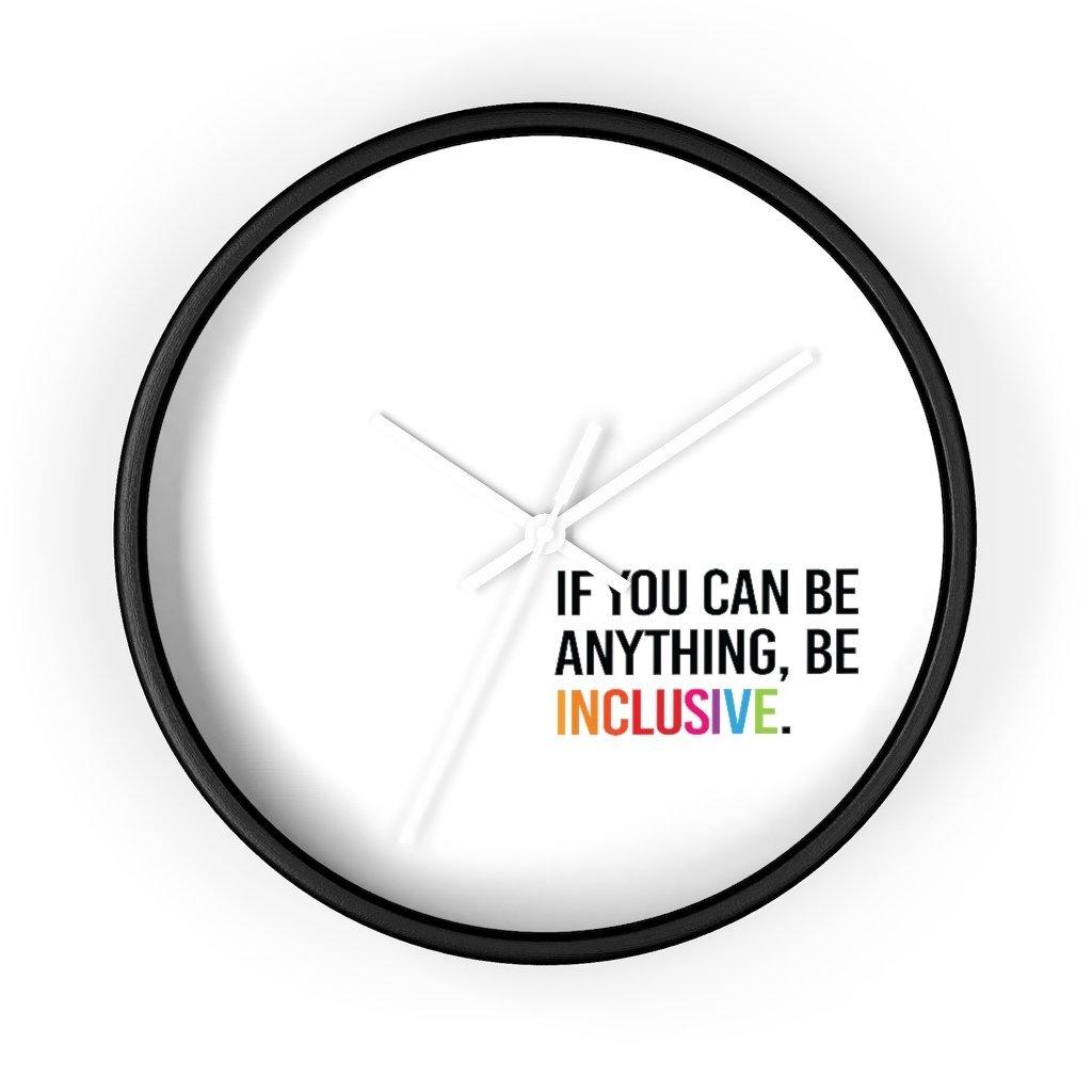 The clock has a black wooden frame and a white face. The hands are white and there are no numbers. In the bottom white quadrant of the clock face is text printed in all caps: "IF YOU CAN BE ANYTHING, BE INCLUSIVE." All text in black, except "Inclusive" which is in rainbow colors.