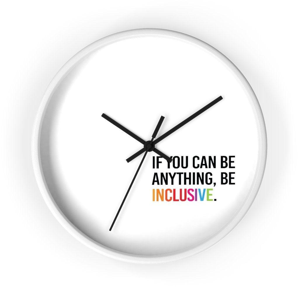 The clock has a white wooden frame and a white face. The hands are black and there are no numbers. In the bottom white quadrant of the clock face is text printed in all caps: "IF YOU CAN BE ANYTHING, BE INCLUSIVE." All text in black, except "Inclusive" which is in rainbow colors.