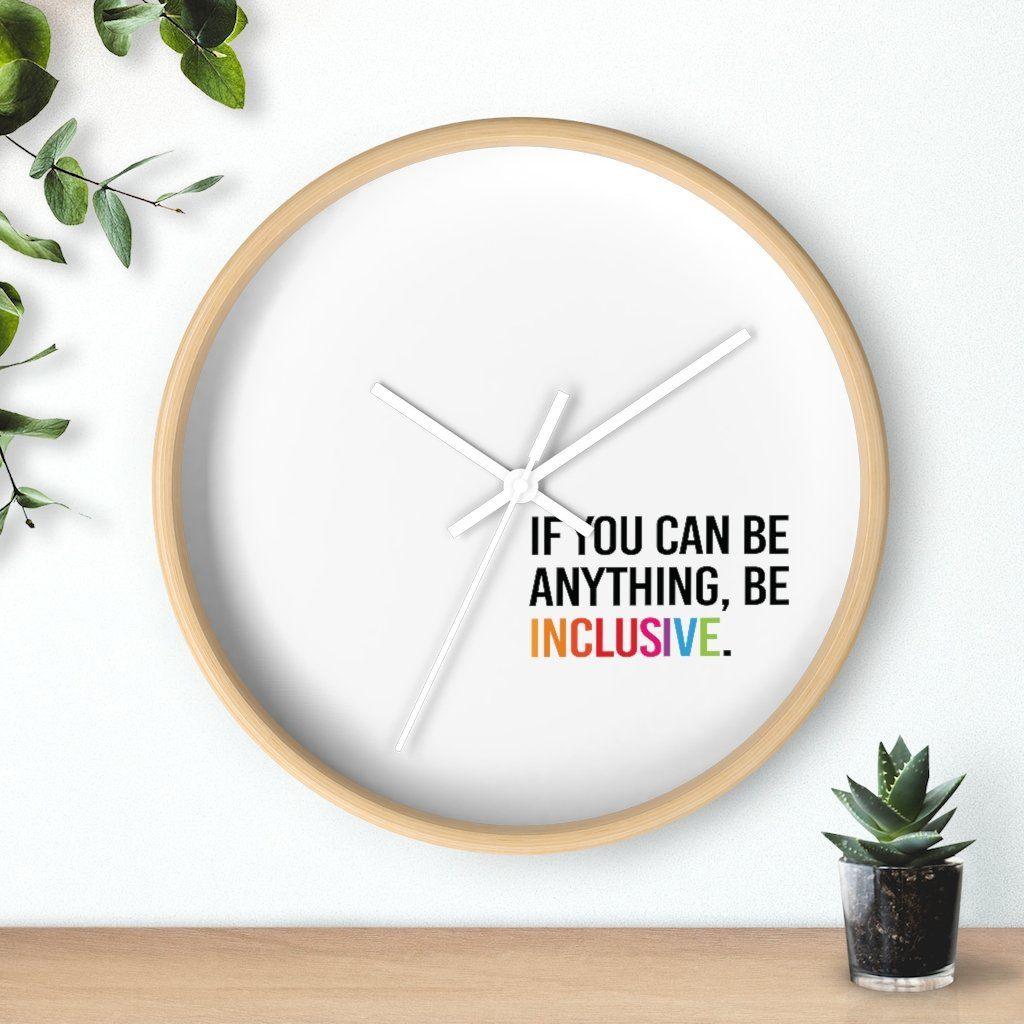 Photo of the clock against a wall with two plants on either side: one hanging from the top left corner and the other in a small pot on a desk.