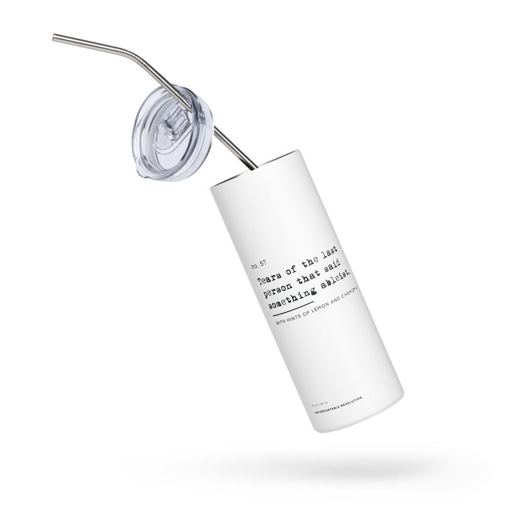 The Ableist Tears Stainless Steel Travel Mug is white, with black text that reads: "no. 57. Tears of the last person that said something ableist. With hints of lemon and chamomile." At the base of the mug is the text: 20oz / 567 gr Uncomfortable Revolution. The mug has a plastic lid and metal straw.