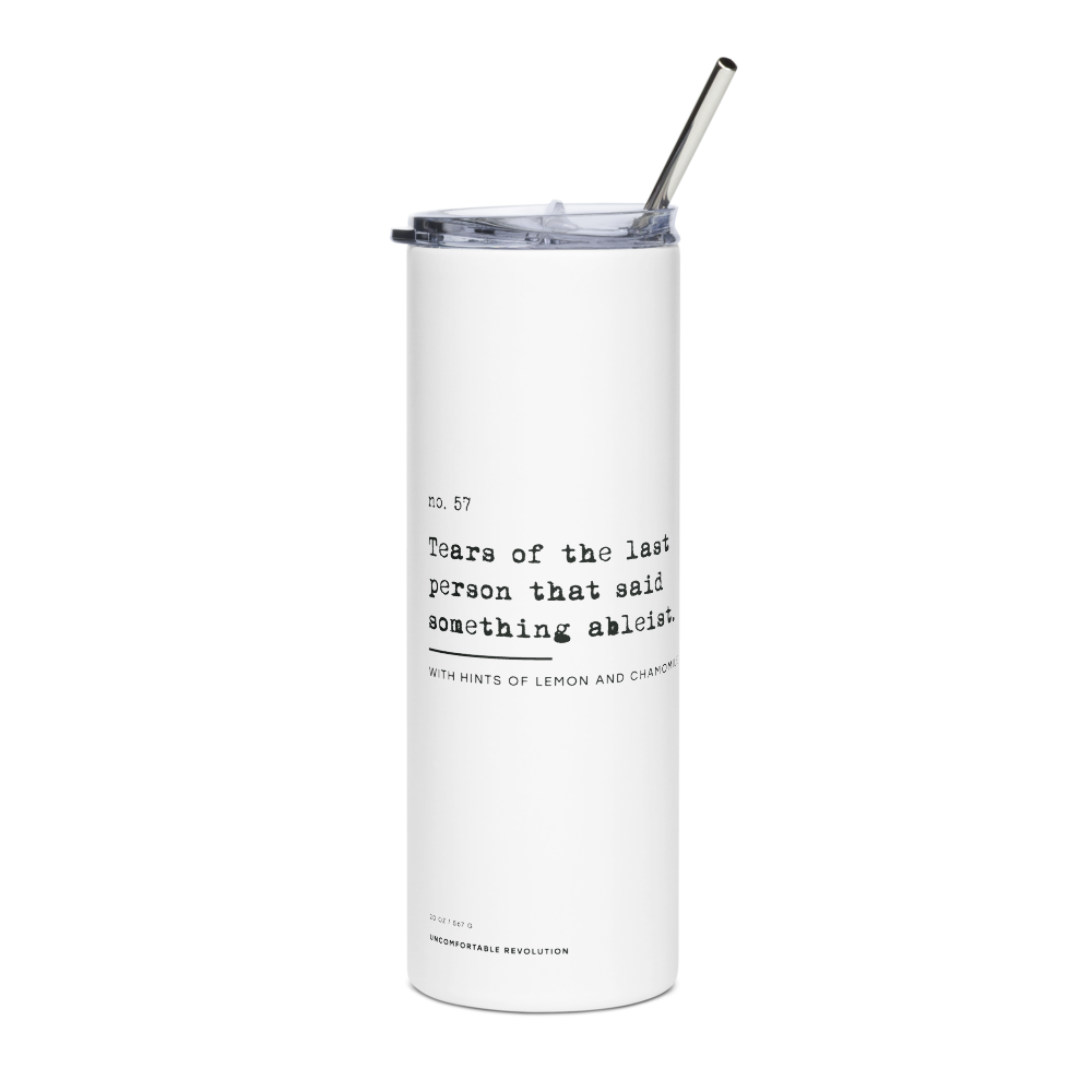 White 20oz stainless steel travel mug from URevolution with black text reading, “no. 57. Tears of the last person that said something ableist. With hints of lemon and chamomile,” plus “20oz / 567 gr Uncomfortable Revolution” at the base, a plastic lid, and a metal straw.