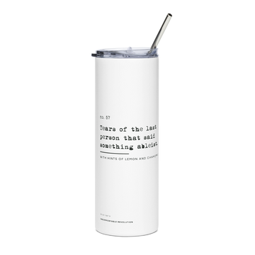 White 20oz stainless steel travel mug from URevolution with black text reading, “no. 57. Tears of the last person that said something ableist. With hints of lemon and chamomile,” plus “20oz / 567 gr Uncomfortable Revolution” at the base, a plastic lid, and a metal straw.
