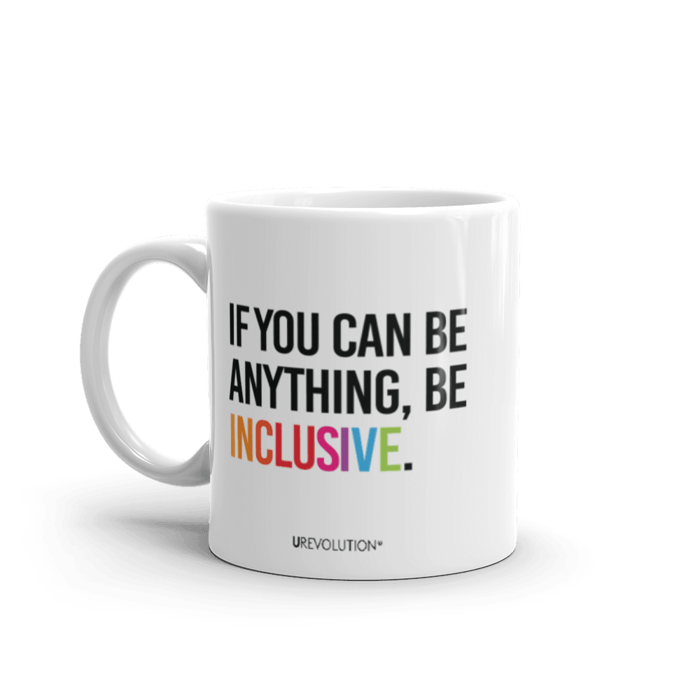 11oz Be Inclusive mug. On the right-hand side of the mug, facing the screen, is the phrase, 'If you can be anything, be inclusive,' printed in large black upper case letters. The word 'inclusive' is in the color of the rainbow. At the bottom edge of the inclusive mug is the word, URevolution, printed in small black upper case letters.