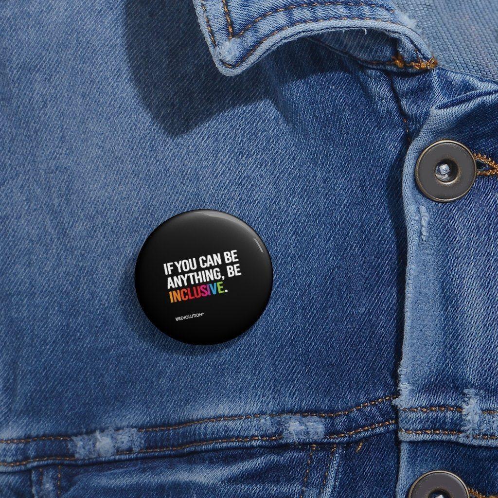  A black Be Inclusive pin. The phrase, "if you can be anything, be inclusive," is printed in upper white case letters. The word inclusive is in the colors of the rainbow.