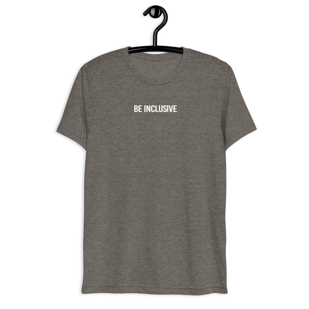 Grey unisex tri-blend Be Inclusive t-shirt. Printed in the middle top one-third of the t-shirt in white upper case letters, about one inch high is the phrase - Be Inclusive. The t-shirt is hanging on a black plastic hanger against a blank wall.