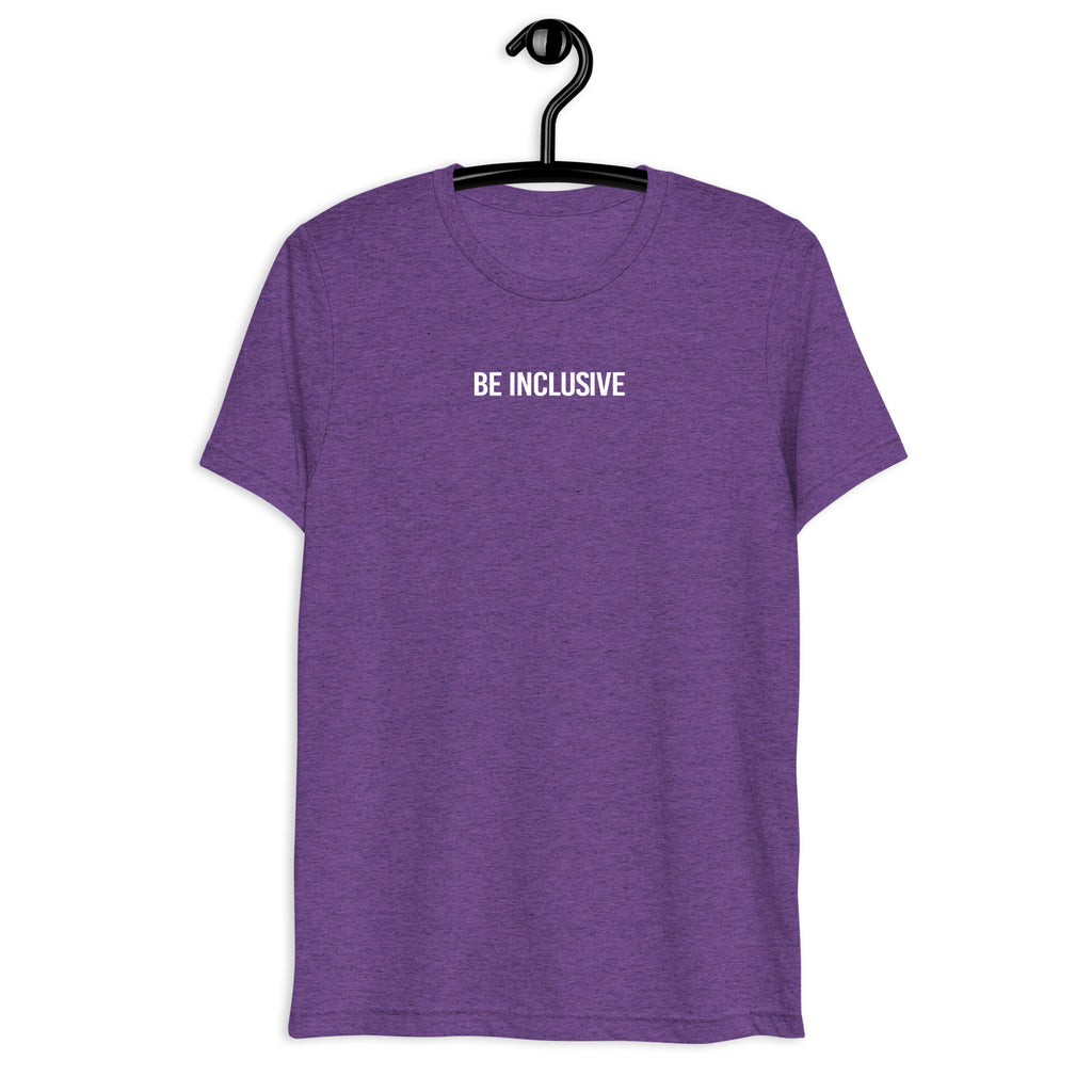 Purple unisex tri-blend Be Inclusive t-shirt. Printed in the middle top one-third of the t-shirt in white upper case letters, about one inch high is the phrase - Be Inclusive. The t-shirt is hanging on a black plastic hanger against a blank wall.