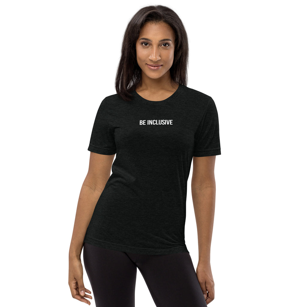 This is a photo of a unisex tri-blend Be Inclusive t-shirt worn by a model. Printed in the middle top one-third of the t-shirt in white upper case letters, about one inch high is the phrase - Be Inclusive. 