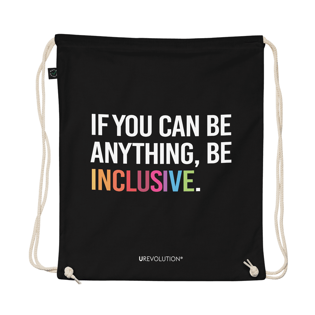 This is a photo of URevolution's black Be Inclusive organic cotton drawstring bag. In the middle of the drawstring bag, printed in large white upper case letters, is the phrase, 'If you can be anything, be inclusive.' The word 'inclusive' is in the color of the rainbow. At the bottom edge of the bag is the word, URevolution, printed in small white upper case letters.