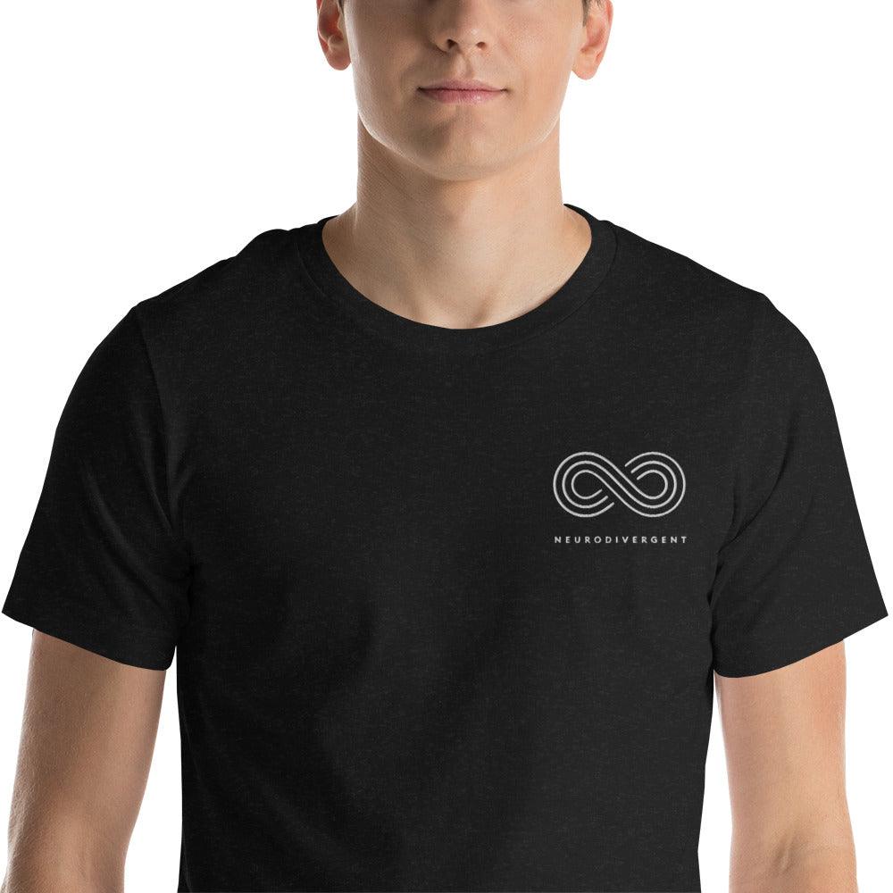 This is a photo of a black heather embroidered Neurodivergent Tee. In the top left third of the Neurodivergent Hoodie, there is an elegant white infinity symbol consisting of three interwoven white lines. Under the symbol is the word, 'neurodivergent.' The neurodivergent t-shirt is worn by a black model. Only their torso is visible.