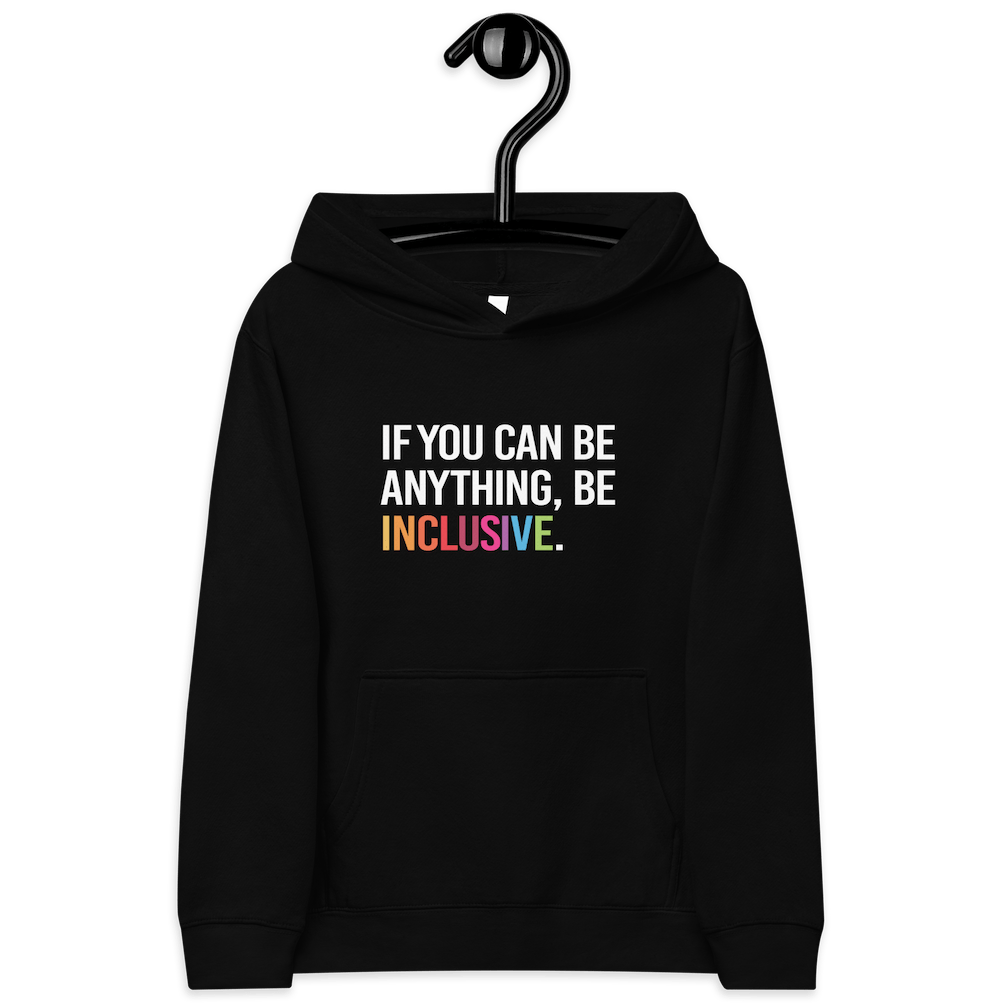This is a photo of a black be inclusive kids hoodie. In the top one-third of kids hoodie, in white upper case letters, is the phrase: 'if you can be anything, be inclusive.' The word inclusive is in the colors of the rainbow. The hoodie is on a hanger.