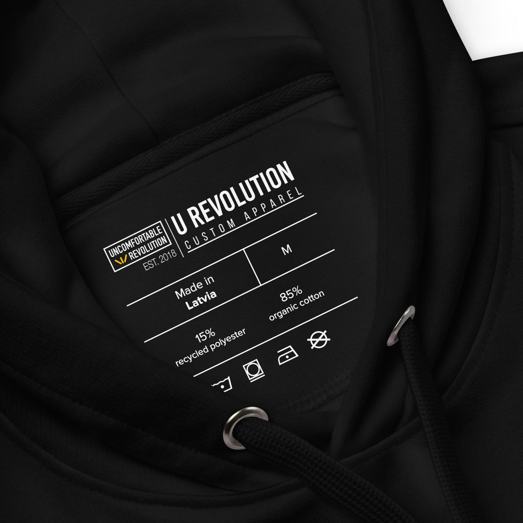 Photo of a black premium eco-friendly be inclusive hoodie. The image shows the URevolution clothing label and the product specifications: made in Latvia, size M, 15% recycled polyester, 85% organic cotton. 