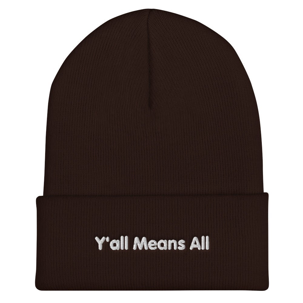 This is a photo of a brown-colored Y'all Means All beanie. On the front of the beanie the phrase, 'Y'all Means All,' is embroidered on it in white title case letters. 