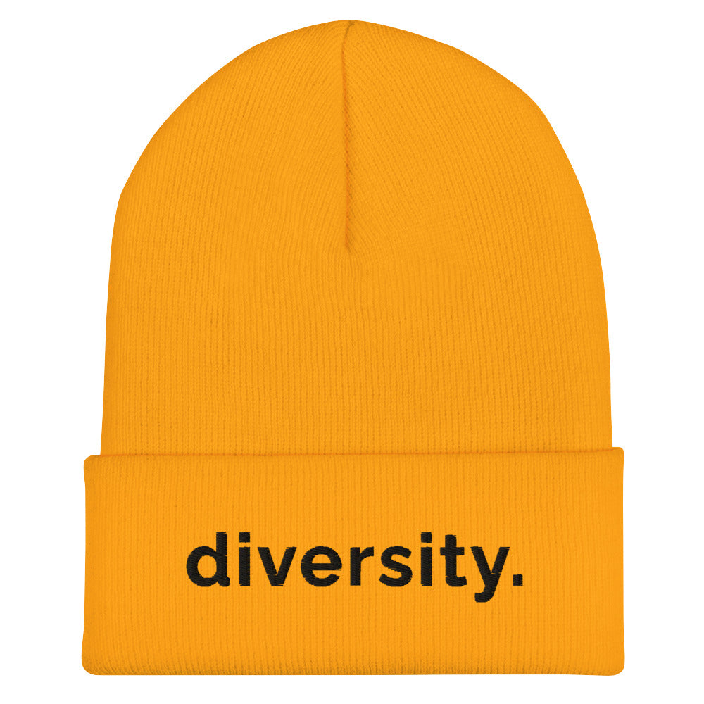 A gold diversity beanie has the word 'diversity' embroidered on the front cuff in black bold lower case letters.