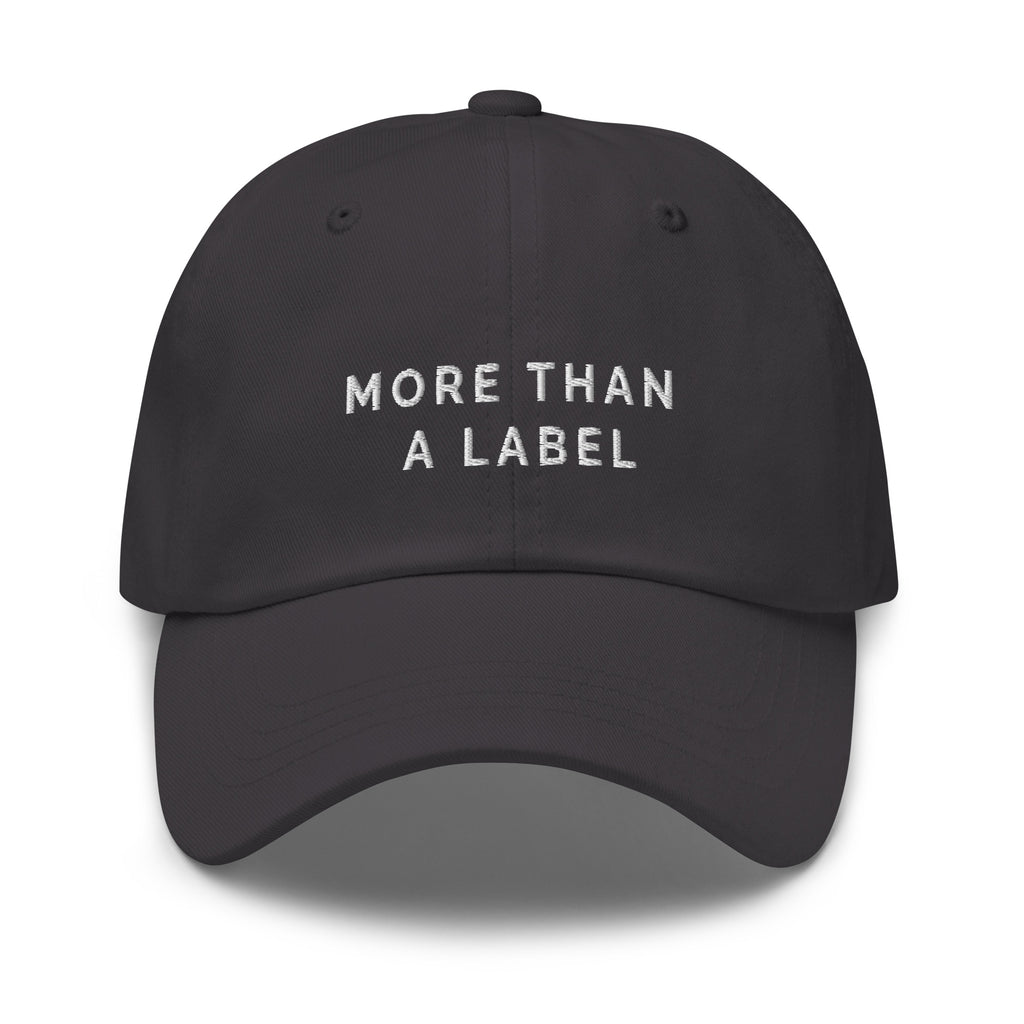 A dark-gray More Than A Label cap. In the middle of the cap is the phrase, 'More Than A Label,' embroidered in white upper case letters.