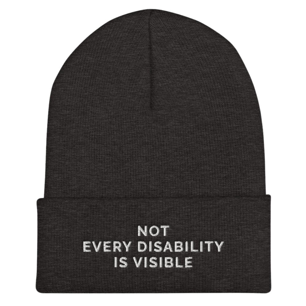 A photo of a dark gray hypoallergenic Not Every Disability Is Visible Beanie lying flat against a plain background. On the cuff of the beanie the phrase, 'Not Every Disability Is Visible,' is embroidered on it over three lines in white upper case letters.