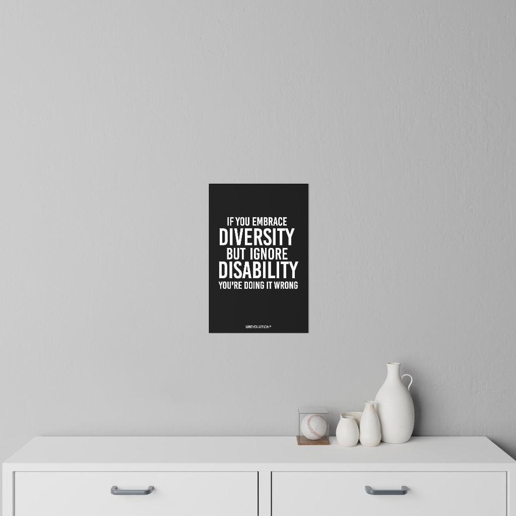This is a photo of an Embrace Diversity decal. In the middle of the decal is the phrase, printed in white upper case letters, "If you embrace diversity, but ignore disability, you're doing it wrong." The phrase takes up 75% of the decal. At the bottom of the decal, in small white upper case letters, is the brand name URevolution. The 12" x 18" decal is on a gray wall above a chest of drawers.