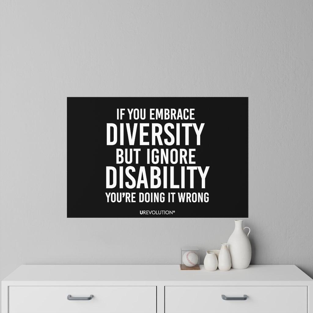 This is a photo of an Embrace Diversity decal. In the middle of the decal is the phrase, printed in white upper case letters, "If you embrace diversity, but ignore disability, you're doing it wrong." The phrase takes up 75% of the decal. At the bottom of the decal, in small white upper case letters, is the brand name URevolution. The size of the decal is 36" x 24". The decal is positioned on a gray wall above a chest of doors.