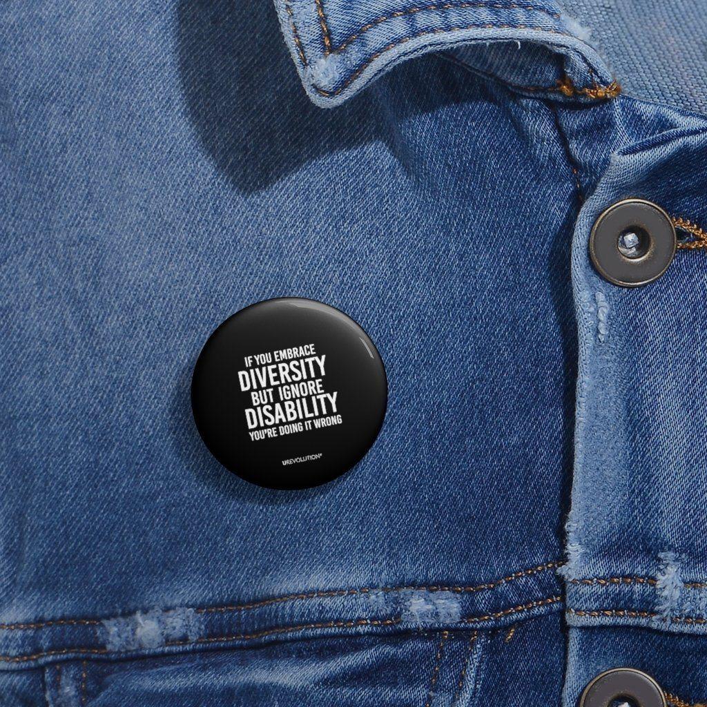 Embrace diversity pin. The embrace diversity pin features the phrase, printed in white upper case letters on a black backgound, "If you embrace diversity but ignore disability, you're doing it wrong." The embrace diversity pin is pinned on a denim jacket.