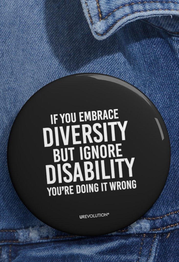 Embrace diversity pin. The embrace diversity pin features the phrase, printed in white upper case letters on a black backgound, "If you embrace diversity but ignore disability, you're doing it wrong." The embrace diversity pin is pinned on a denim jacket.