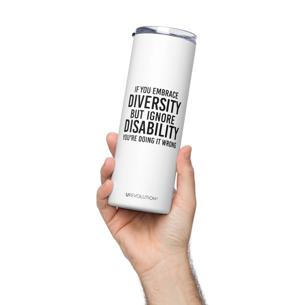 A 20 oz Embrace Diversity stainless steel travel mug. The mug has a stainless steel straw and plastic lid. In the middle of the mug is the phrase, printed in black upper case letters, 'If you embrace diversity, but ignore disability, you're doing it wrong.' The cylindrical mug has a plastic lid and stainless steel mug. 