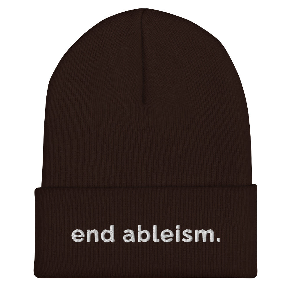 A brown End Ableism Beanie has the words 'end ableism.' embroidered in white lowercase letters on the front of the beanie.