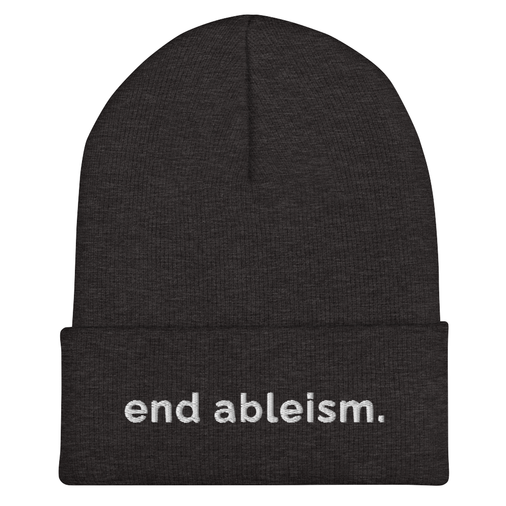 A dark grey End Ableism Beanie has the words 'end ableism.' embroidered in white lowercase letters on the front of the beanie.