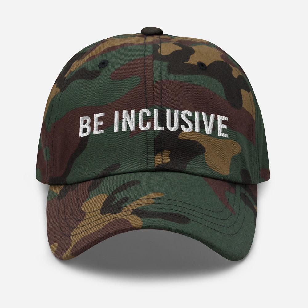 This is a photo of the front of a green chamo cotton twill 'be inclusive cap,' with the phrase "Be Inclusive" embroidered on the front in upper case white letters.