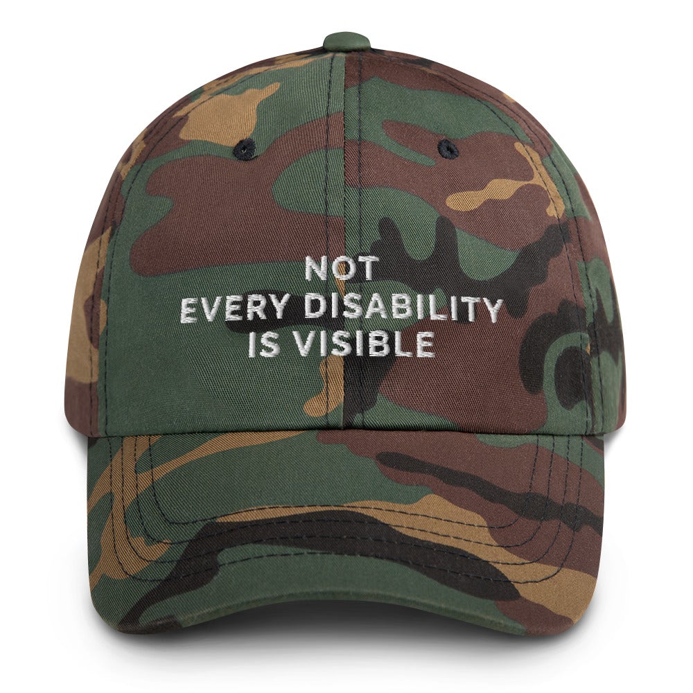 This is a photo of a green-camouflaged-colored 'not every disability is visible' cap. Embroidered, on the front of the cap in white upper case letters, is the phrase 'Not Every Disability Is Visible.'