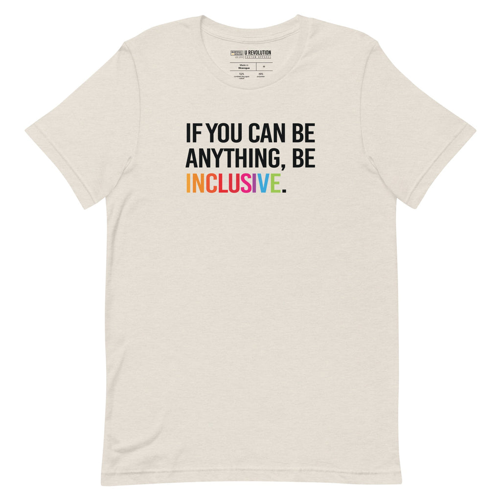 This is a photo of a heather-dust rainbow classic Be Inclusive tee. On the front of the inclusive t-shirt is the phrase: "If you can be anything, be inclusive," in black upper case letters. All the text is in black, except "Inclusive," which is in rainbow colors.