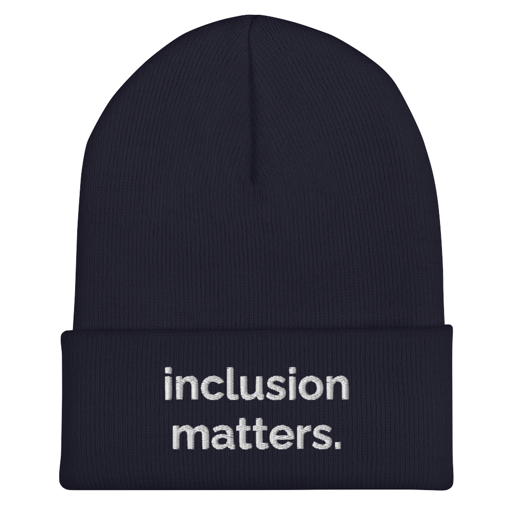 A navy Inclusion Matters beanie against a plain white background. On the front of the beanie the phrase, 'Inclusion Matters,' is embroidered on it in white sentence case letters over two lines.