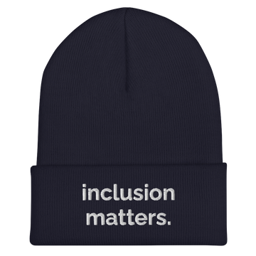 A navy Inclusion Matters beanie against a plain white background. On the front of the beanie the phrase, 'Inclusion Matters,' is embroidered on it in white sentence case letters over two lines.