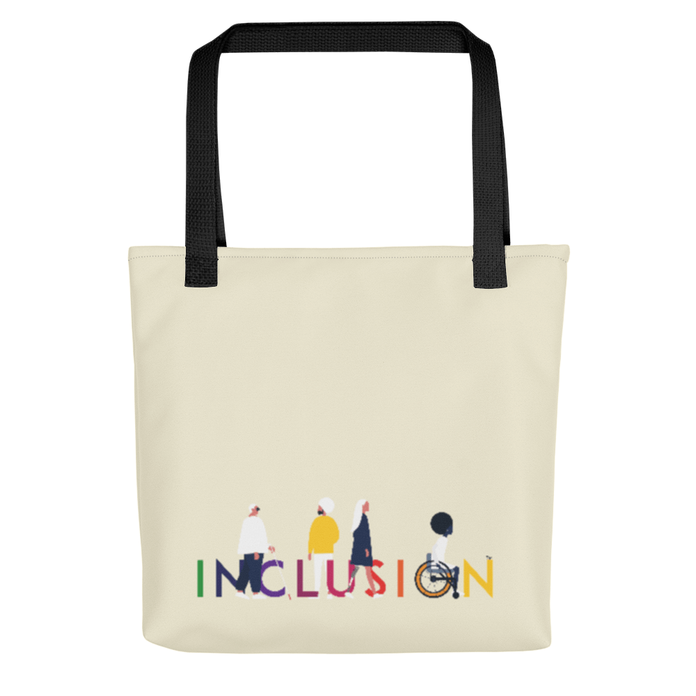 A disability inclusion tote bag has the word INCLUSION printed in rainbow-like colors on one side. The inclusion tote is canvas color with black straps. Four diverse disabled people have incorporated into the phrase INCLUSION: a blind person, a person with an invisible illness, a disabled person with a prosthetic limb, and a disabled person in a wheelchair.