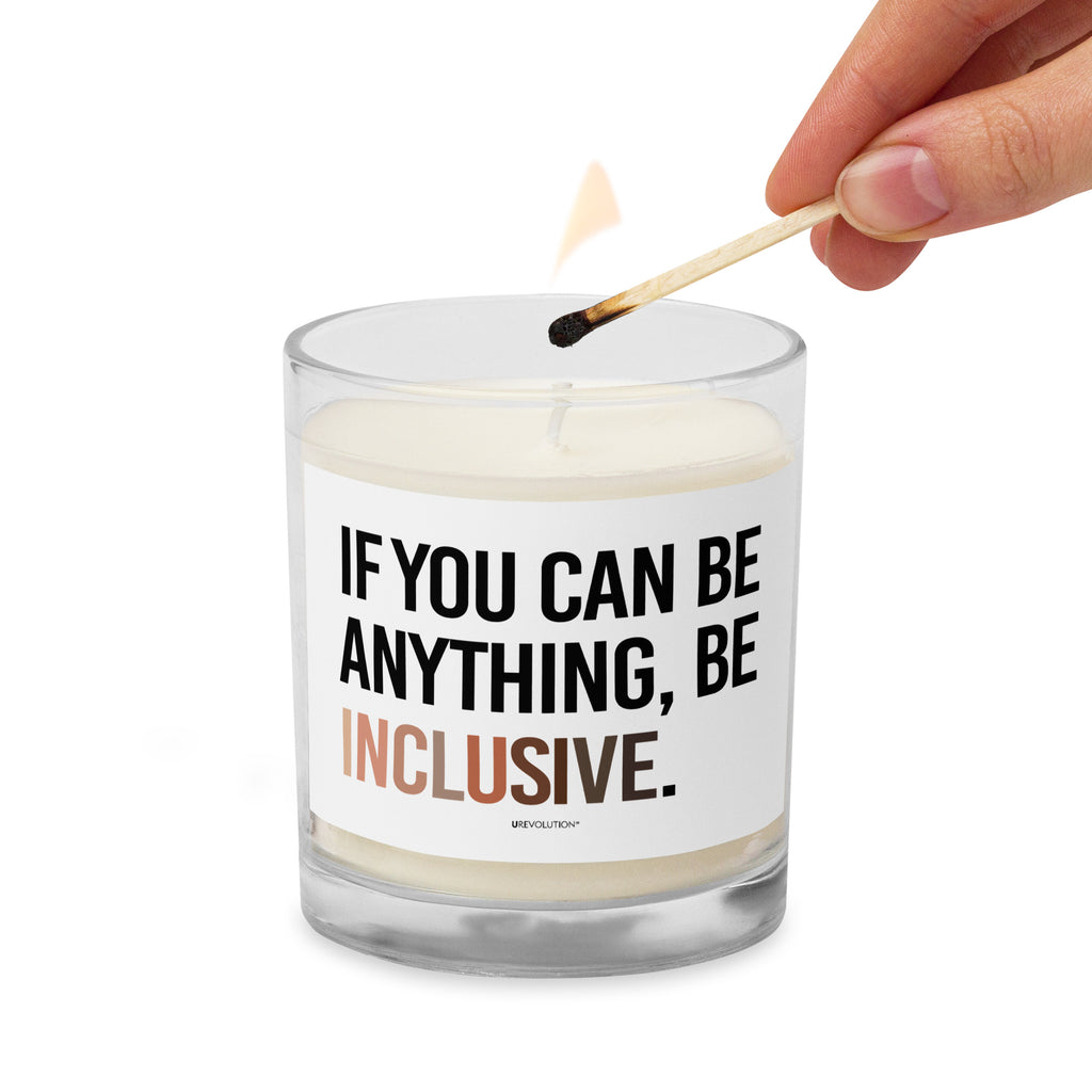 A Be Inclusive Diversity candle. On the front of the diversity candle is the phrase: "If you can be anything, be inclusive," in upper case letters printed on a white label. The text is all black, except the word "Inclusive," which is in different skin colors, with the lightest color on the left and the darkest on the right. The candle is being lit by a match.