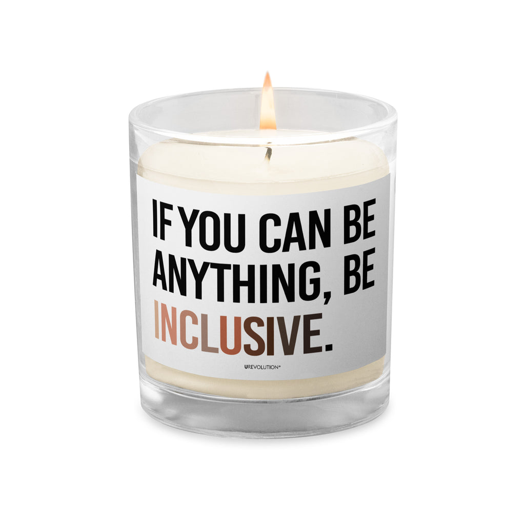 A Be Inclusive Diversity candle. On the front of the diversity candle is the phrase: "If you can be anything, be inclusive," in upper case letters printed on a white label. The text is all black, except the word "Inclusive," which is in different skin colors, with the lightest color on the left and the darkest on the right. The candle is alight.