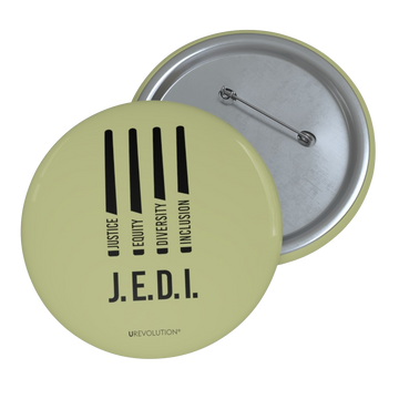 A photo of a J.E.D.I army pin by URevolution. In the middle of the army green pin are four black laser swords. At the bottom of each saber representing the saber handle is one word: Justice Equity Diversity Inclusion. Beneath the laser swords is the acronym J.E.D.I.
