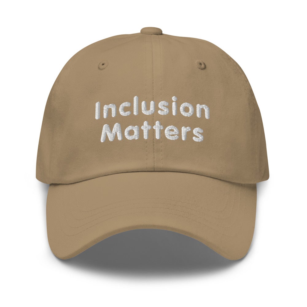 This is a photo of a khaki Inclusion Matters Baseball Cap. On the front of the baseball cap above the visor are two words, 'Inclusion Matters.' printed in white sentence case letters over two lines.