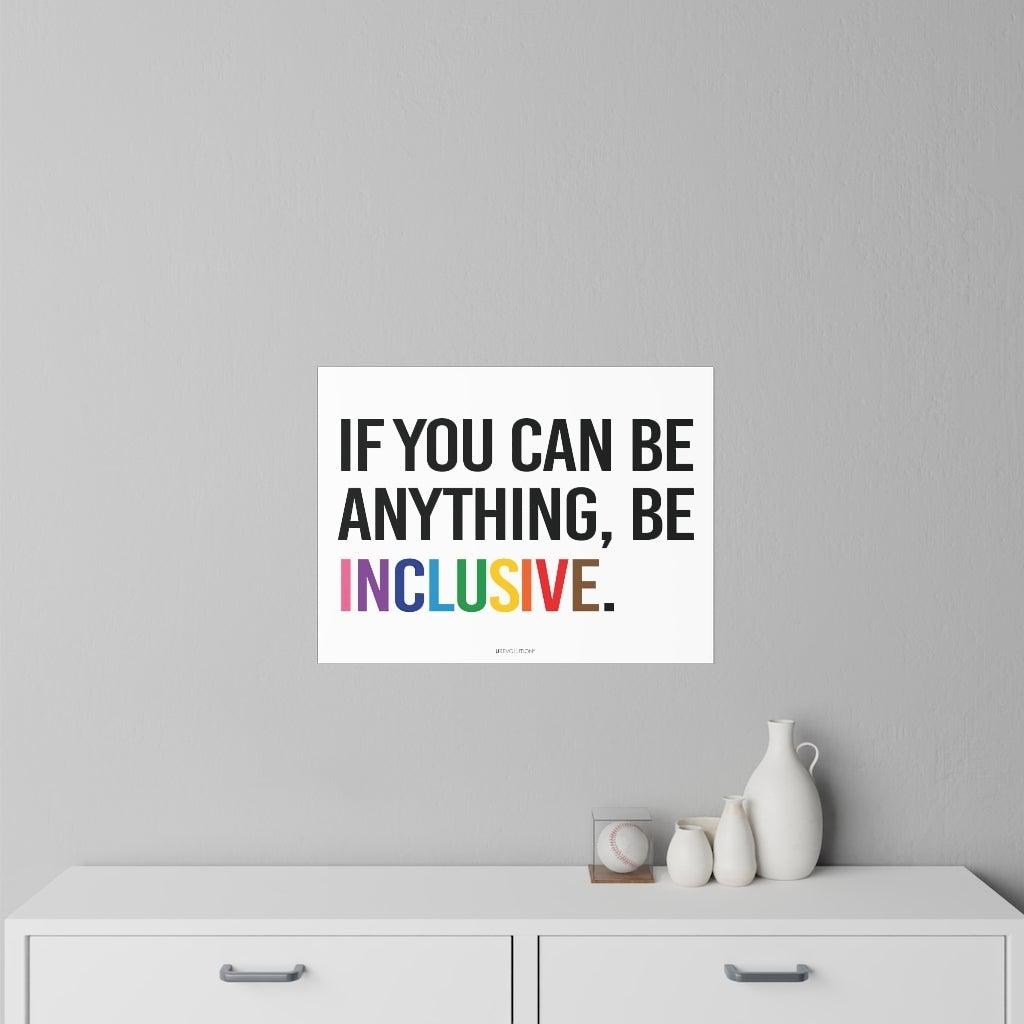 This is a photo of a Be Inclusive decal. In the middle of the wall decal, taking up 90% of the surface area is the quote in upper case letters: "If you can be anything, be inclusive." The words - be inclusive - are in the colors of the rainbow. The inclusive decal is placed on a gray wall above a set of draws.
