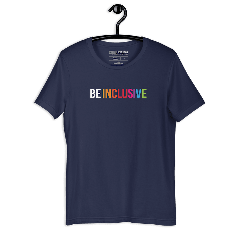 Navy Be Inclusive t-shirt with text printed in big caps says "BE INCLUSIVE". BE is in white, and INCLUSIVE is in rainbow colors. Both words are in one line across the top of the shirt. The shirt is on a black hanger.