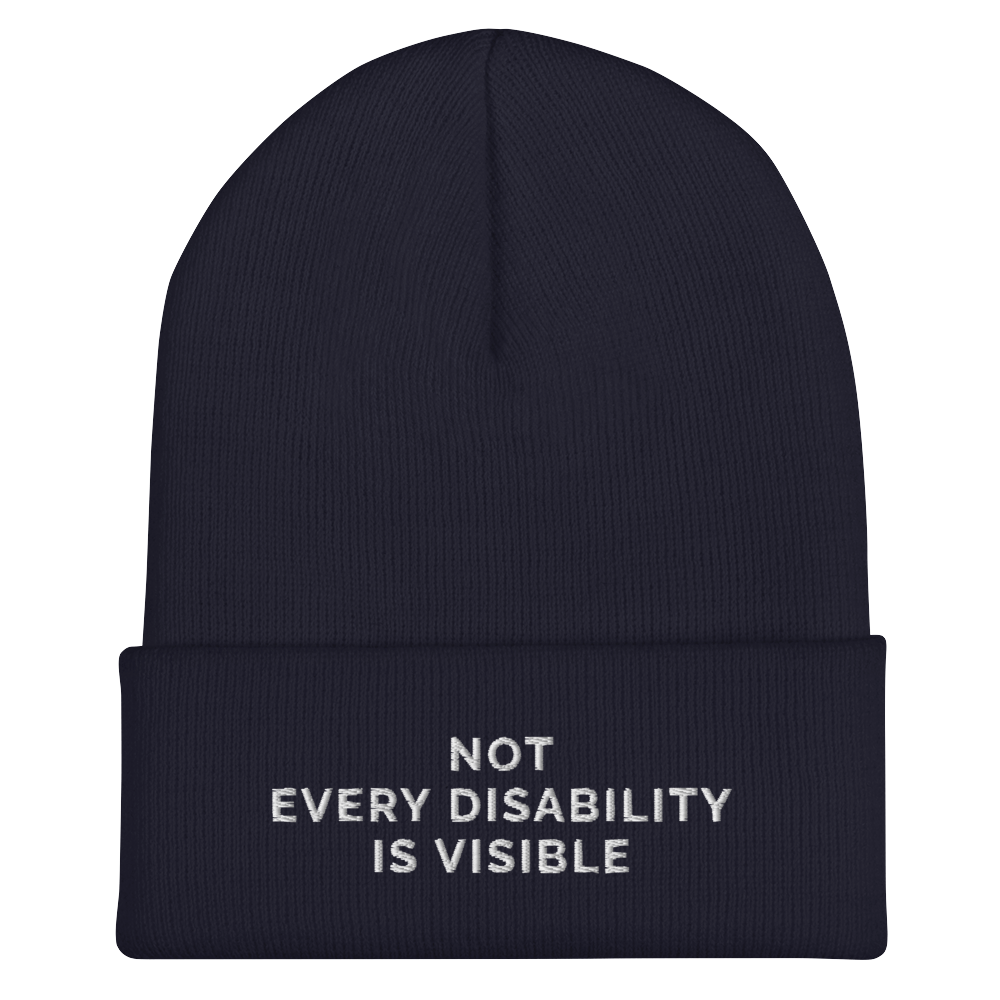 Beanie Inspo - a photo of a navy hypoallergenic Not Every Disability Is Visible Beanie lying flat against a plain background. On the cuff of the beanie the phrase, 'Not Every Disability Is Visible,' is embroidered on it over three lines in white upper case letters.