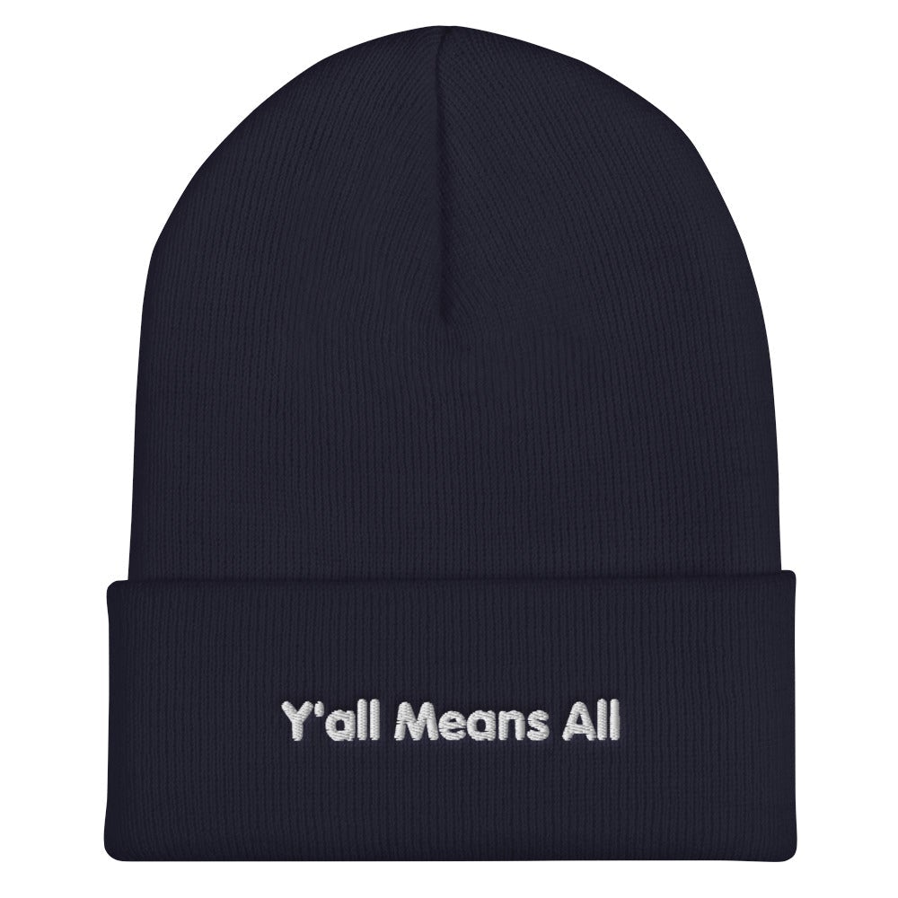 This is a photo of a navy-colored Y'all Means All beanie. On the front of the beanie the phrase, 'Y'all Means All,' is embroidered on it in white title case letters. 