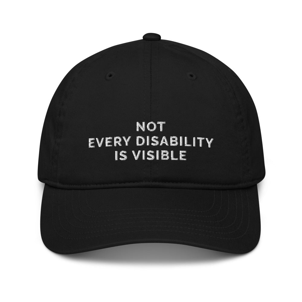 This is a photo of an organic black Not Every Disability Is Visible cap lying flat against a plain background. On the front panel of the cap is the phrase, 'Not Every Disability Is Visible,' embroidered on over three lines in white upper case letters.