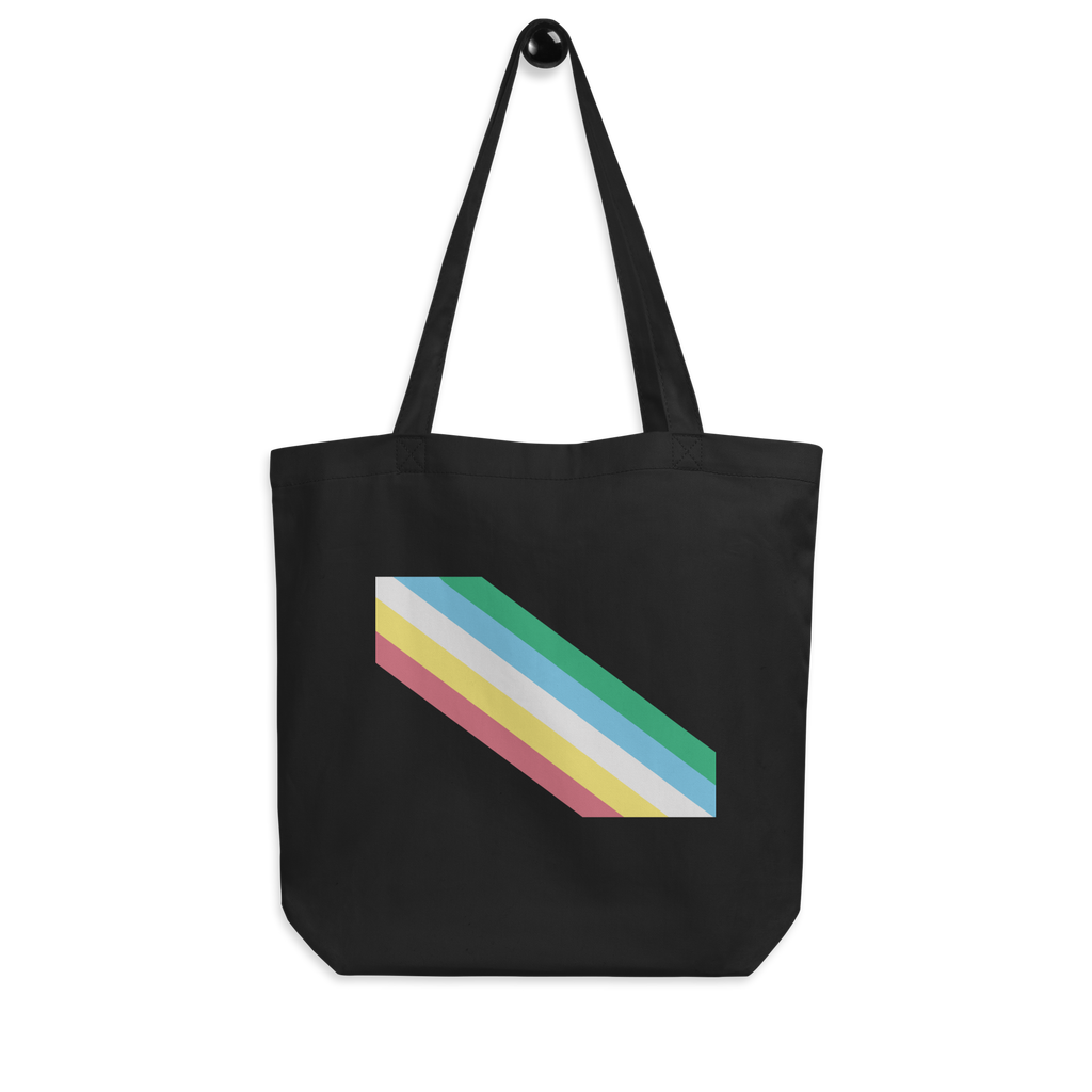 This is an image of an organic disability pride flag tote bag. In the middle of the black tote bag there are five diagonal stripes in this order: red, yellow, white, blue, and green (when looking from the bottom up).