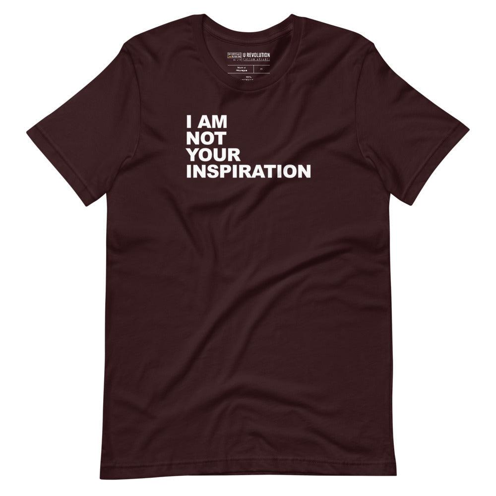 This is a ox-blood 'I Am Not Your Inspiration" t-shirt. On the top third of the inspiration shirt is the phrase, "I am not your inspiration," printed over four lines in white upper case letters.