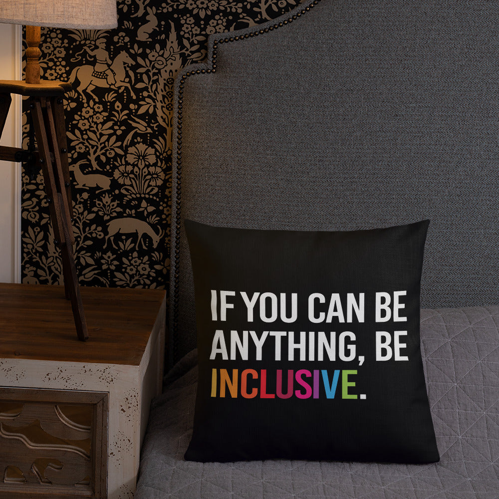 This is an image of a black premium Be Inclusive throw cushion. In the middle of the square throw cushion, the following phrase is printed in white upper case letters, "IF YOU CAN BE ANYTHING, BE INCLUSIVE." The word INCLUSIVE is in rainbow-like colors. 