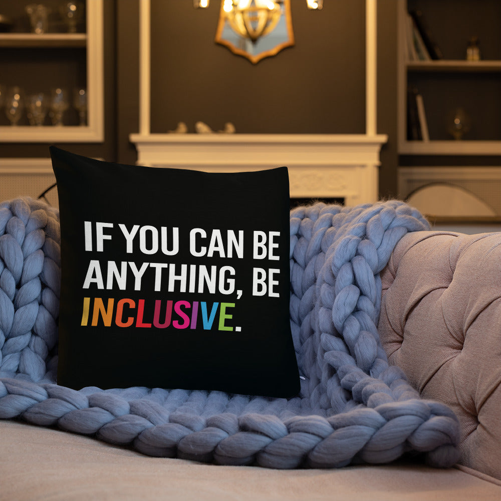 This is an image of a black premium Be Inclusive throw cushion. In the middle of the square throw cushion, the following phrase is printed in white upper case letters, "IF YOU CAN BE ANYTHING, BE INCLUSIVE." The word INCLUSIVE is in rainbow-like colors. 