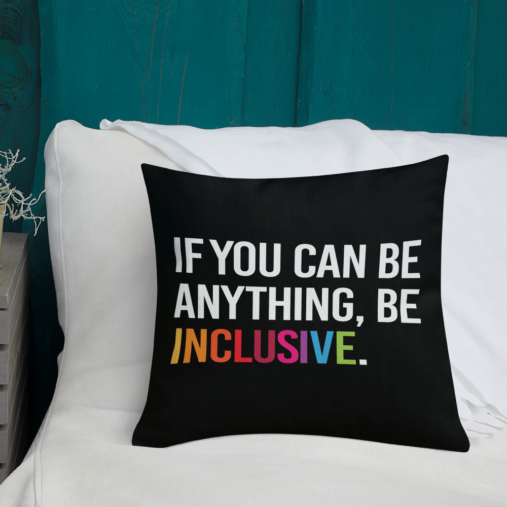 This is an image of a black premium Be Inclusive throw cushion. In the middle of the square throw cushion, the following phrase is printed in white upper case letters, "IF YOU CAN BE ANYTHING, BE INCLUSIVE." The word INCLUSIVE is in rainbow-like colors. 